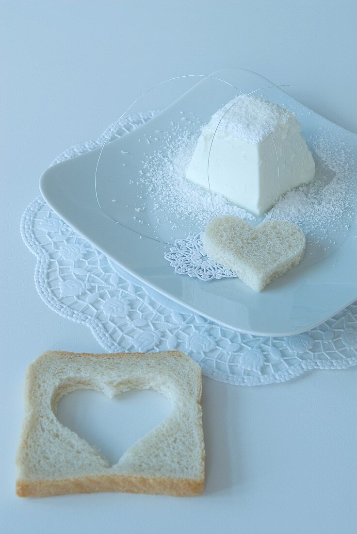 Heart-shaped slice of bread on doily on white place setting