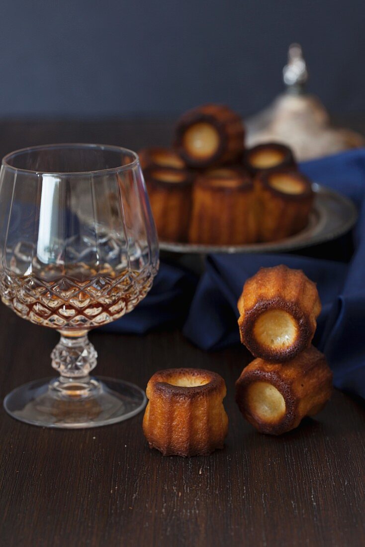 Canelés de Bordeaux (sweet French cakes) and liqueur in a crystal glass