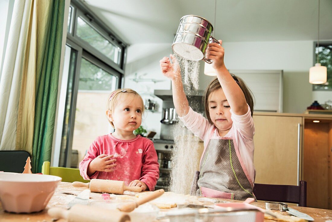 Two children baking biscuits in a kitchen