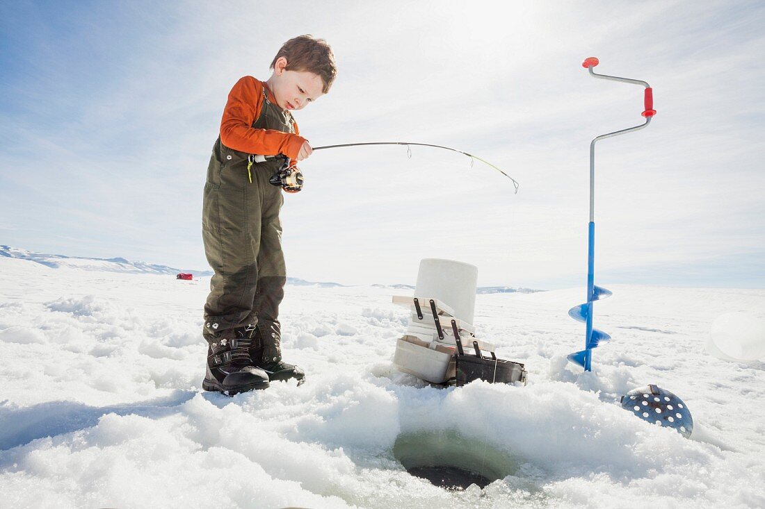 Kleiner Junge beim Eisfischen
