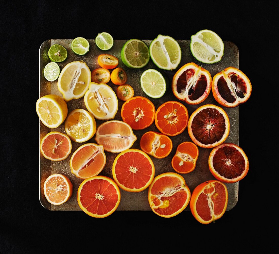 Variety of Sliced Citrus Fruit on Tray, High Angle View