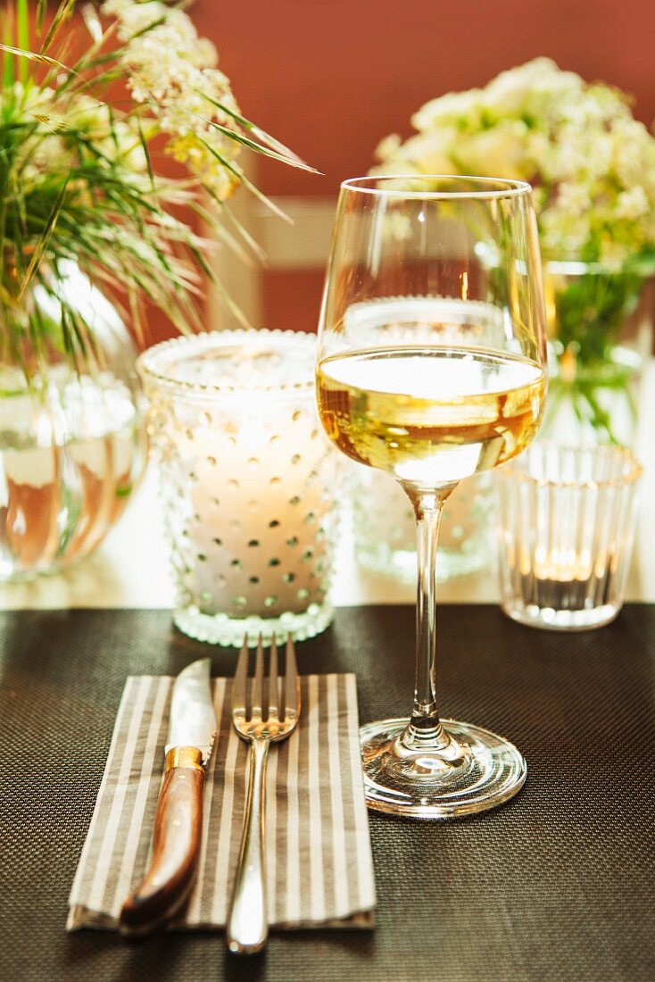 A festively laid table with tealights and flower arrangements