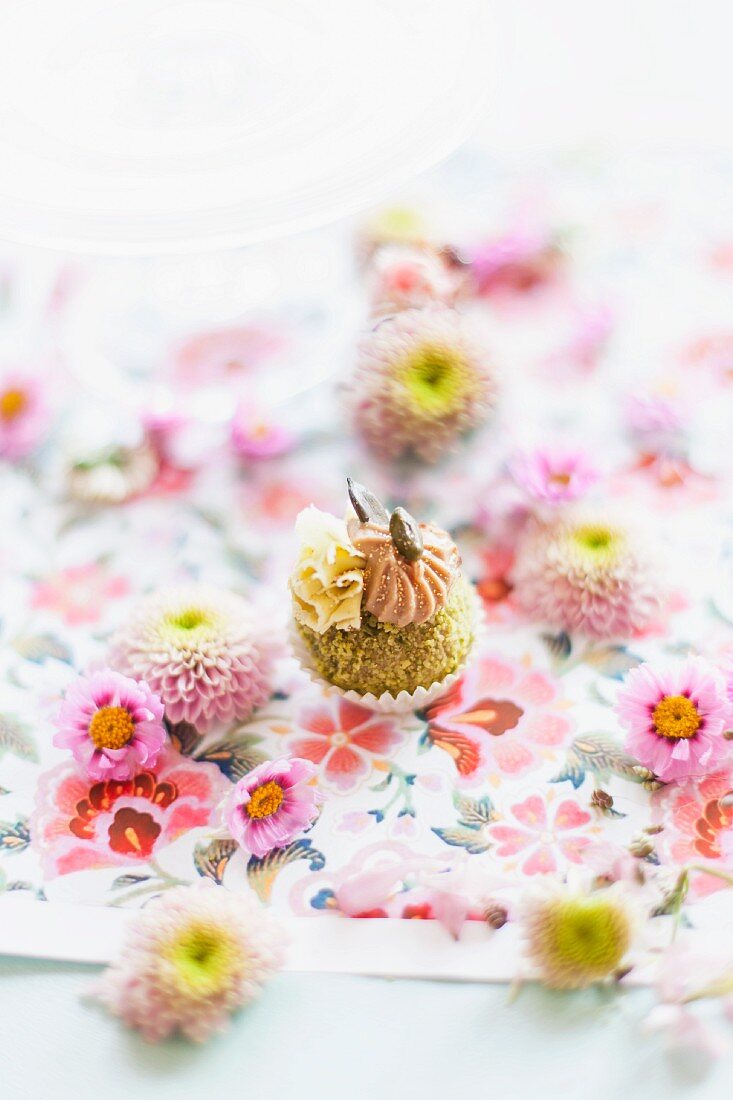 Pistachio confectionery decorated with flowers on a floral tablecloth