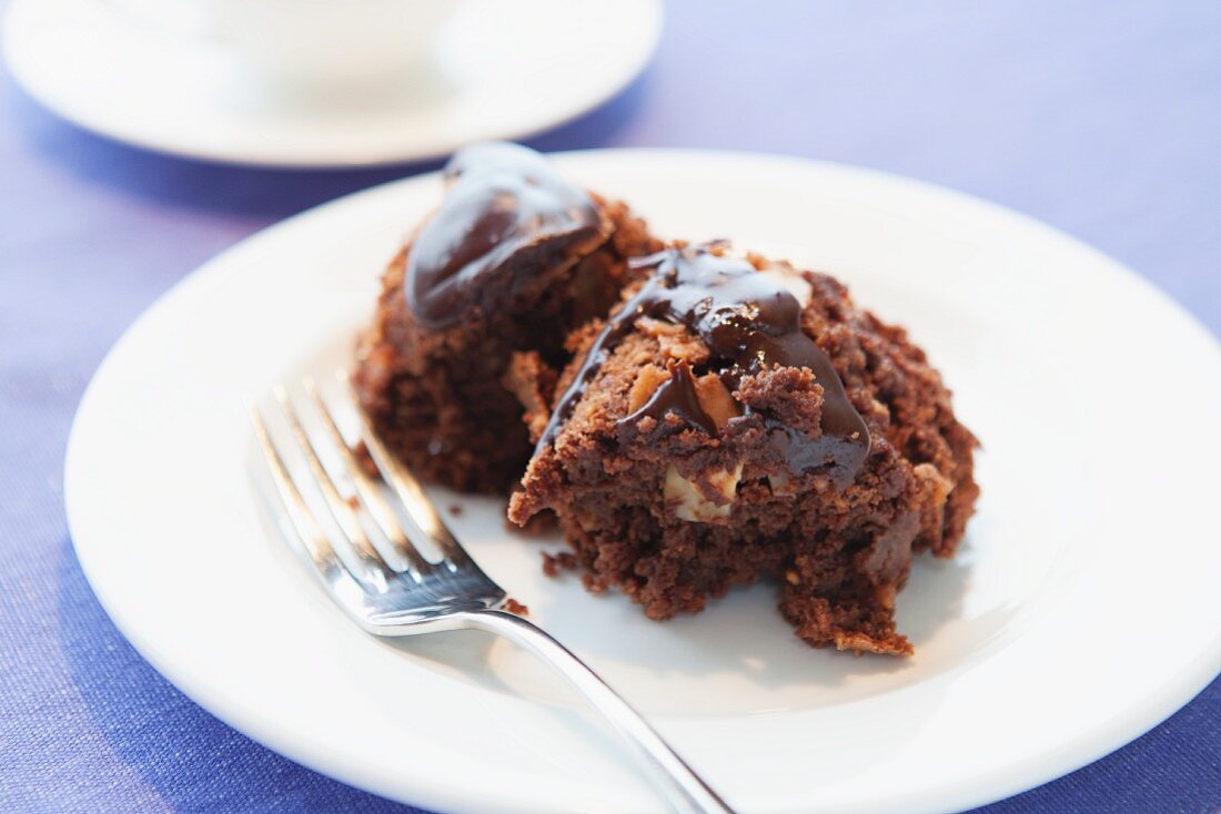 A slice of chocolate cake with nuts on a plate