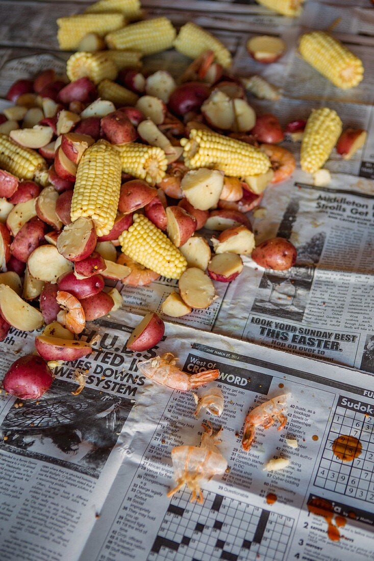 Low Country Boil with Shrimp, Corn, Sausage and Potatoes on Newspaper, High Angle View