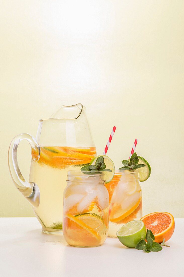 White Wine Sangria in Pitcher and Two Mason Jars with Fruit Garnishing