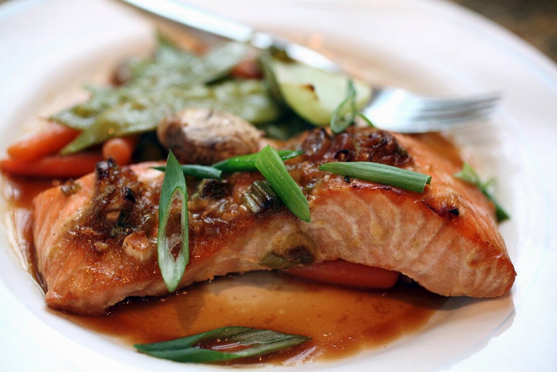 Asian-marinated salmon with steamed vegeatables and chopped scallion garnish