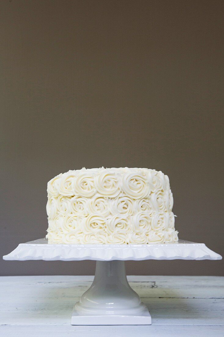 A white wedding cake frosted with roses