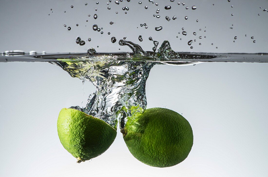 Limes falling into water