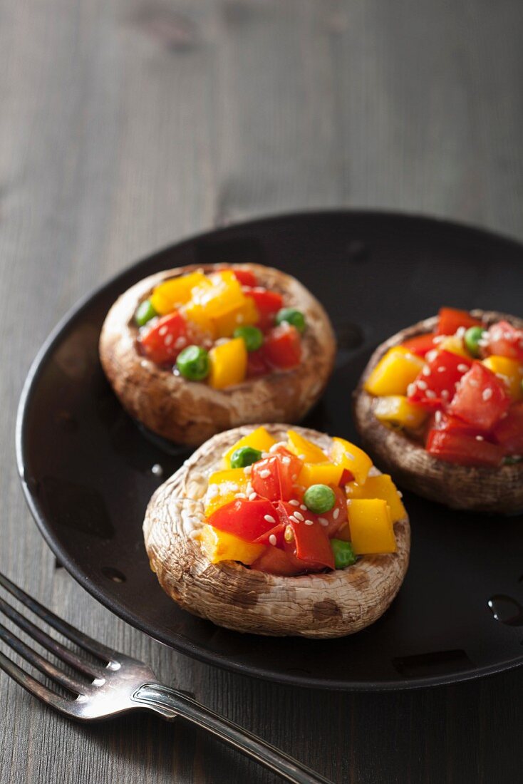 Mushrooms stuffed with tomatoes, yellow peppers and peas