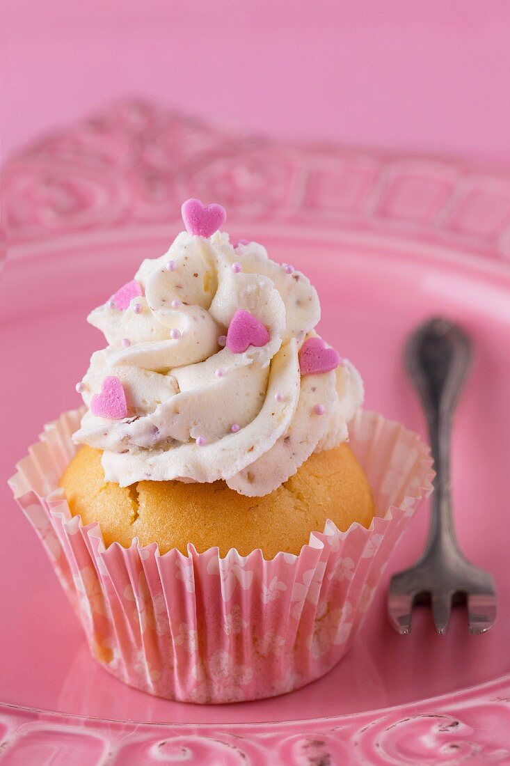 Cupcake mit Buttercreme und rosa Herzen