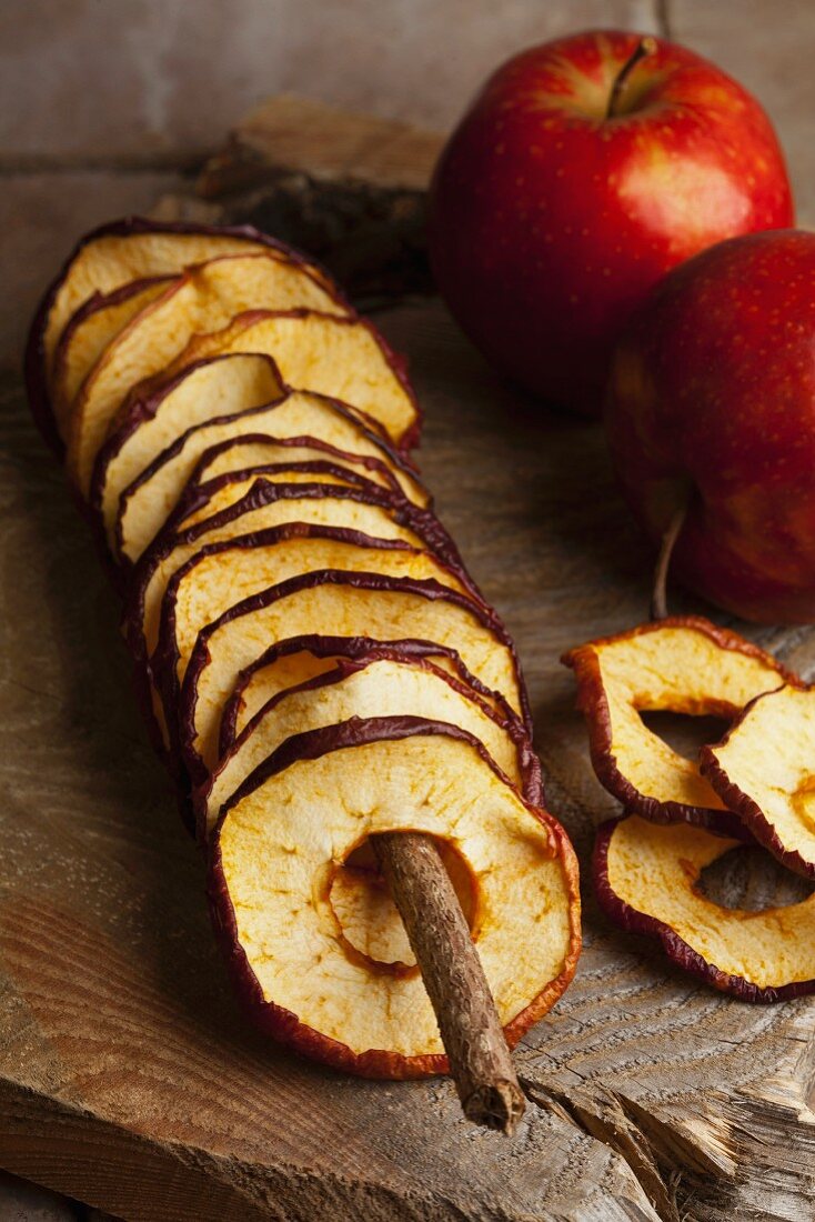 Fried apple rings and fresh apples on a wooden board