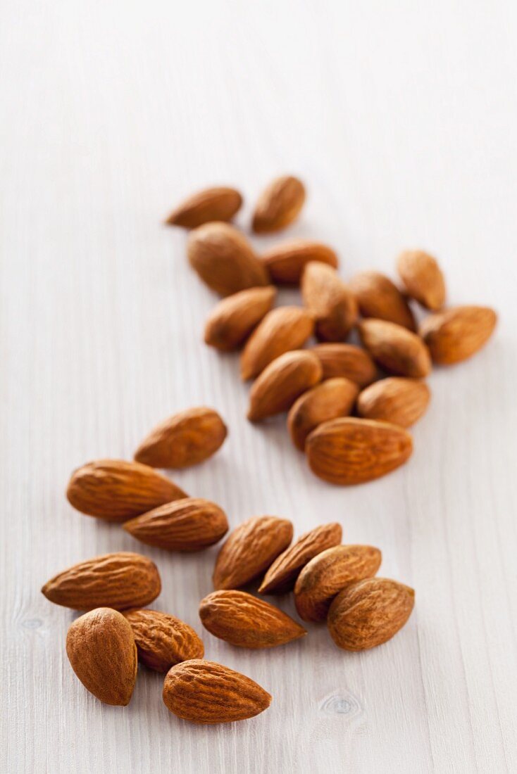 Whole almonds on a white wooden surface