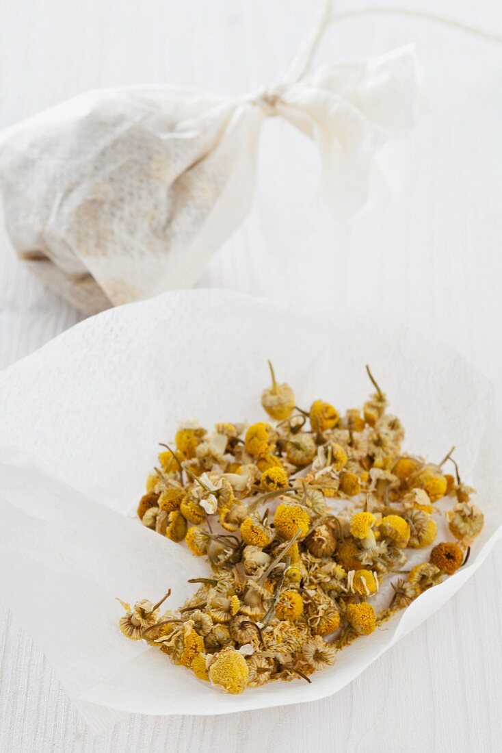 Getrocknete Kamillenblüten in offenem und gebundenem Teebeutel