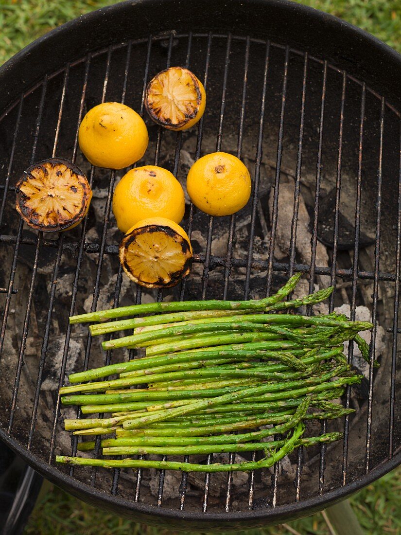 Gegrillter grüner Spargel und Zitronen auf dem Grill