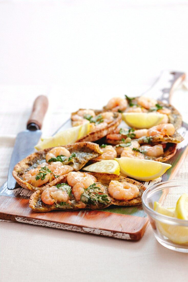 A prawn and green pesto pizza garnished with parsley