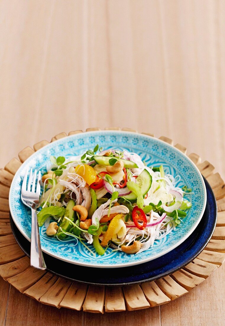A salad made with rice noodles, chicken, pineapple, vegetables and cashew nuts