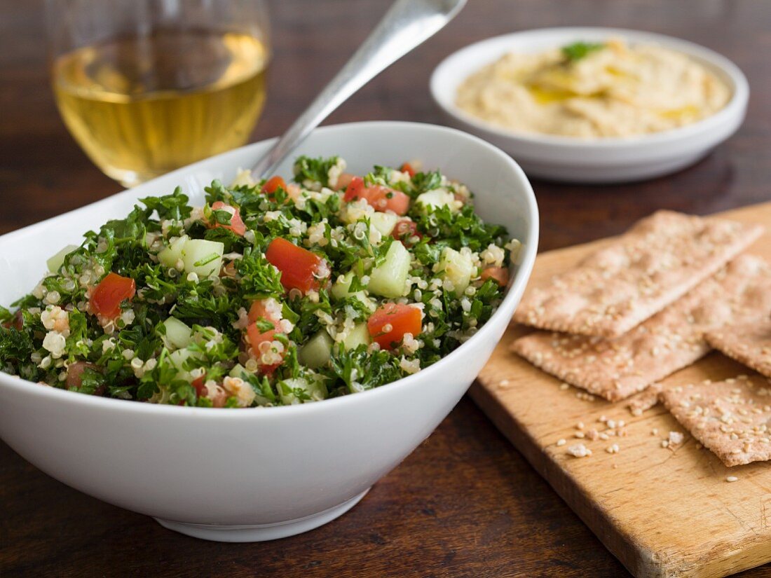 Tabouleh mit Petersilie, Gurken und Tomaten, Cracker und Hummus