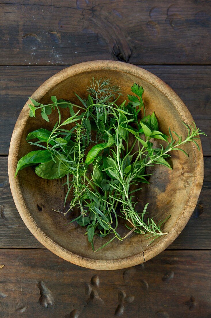 Fresh herbs in a wooden bowl
