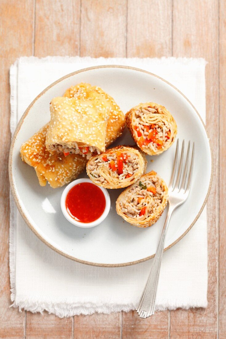 Pfannkuchen-Frühlingsrollen mit chinesischen Nudeln, Hackfleisch und Gemüse gefüllt, dazu süß-saure Sauce