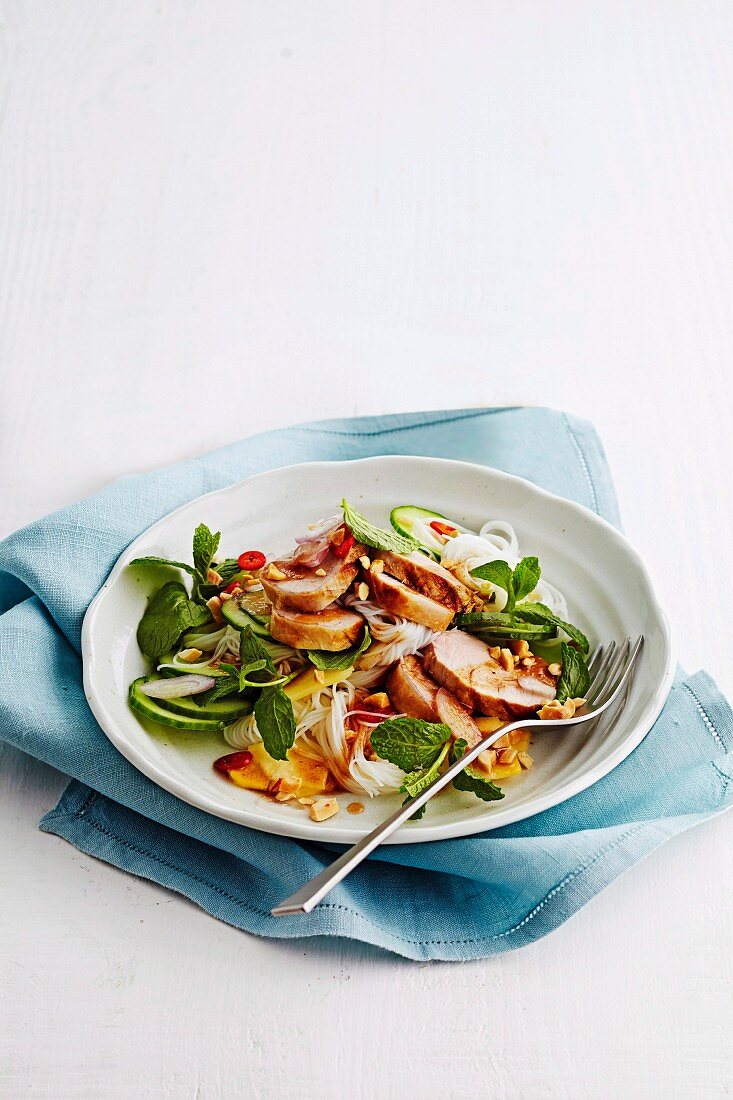 A salad of rice noodles, pork, pineapple and mint