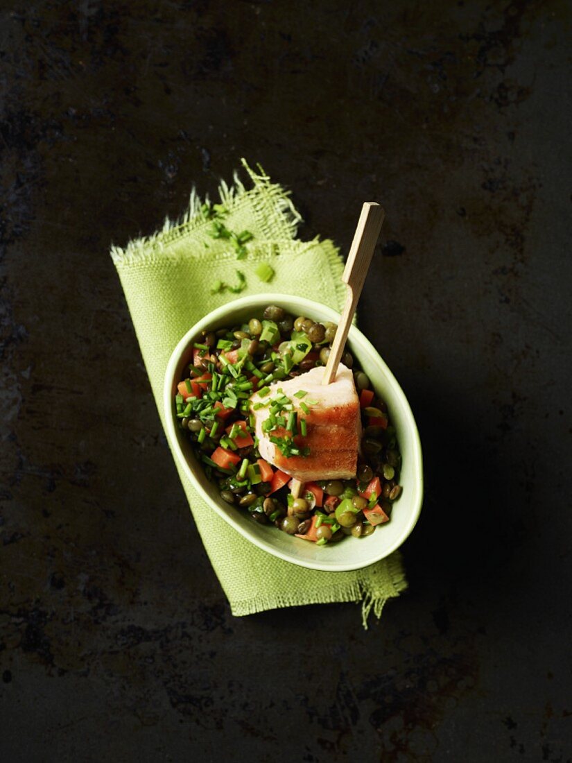 Lentils with a salmon skewer in a bowl