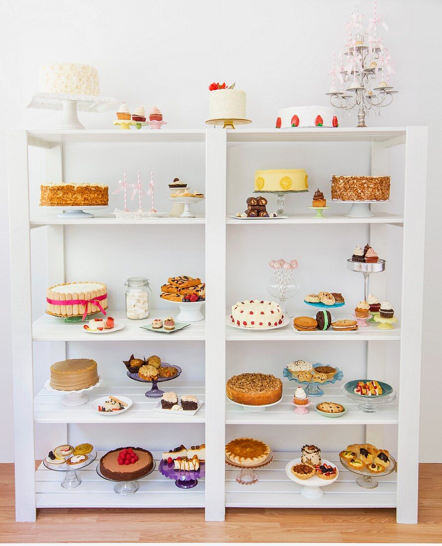 Various desserts, cakes and biscuits on a white shelf
