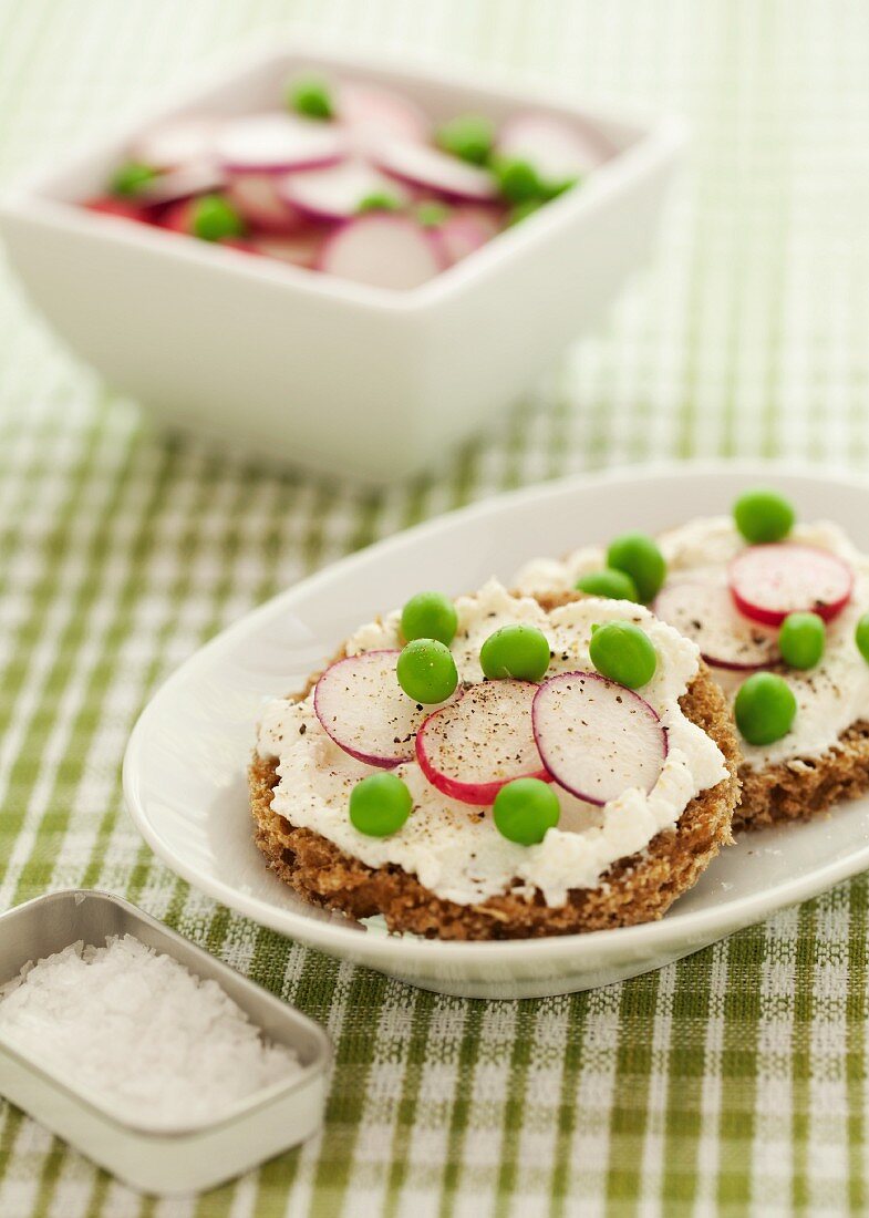 Rye bread topped with ricotta cheese, peas, radishes and pepper