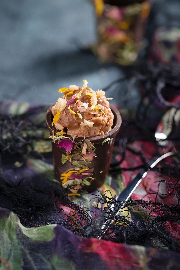 A chocolate cup filled with nougat cream and dried flower petals