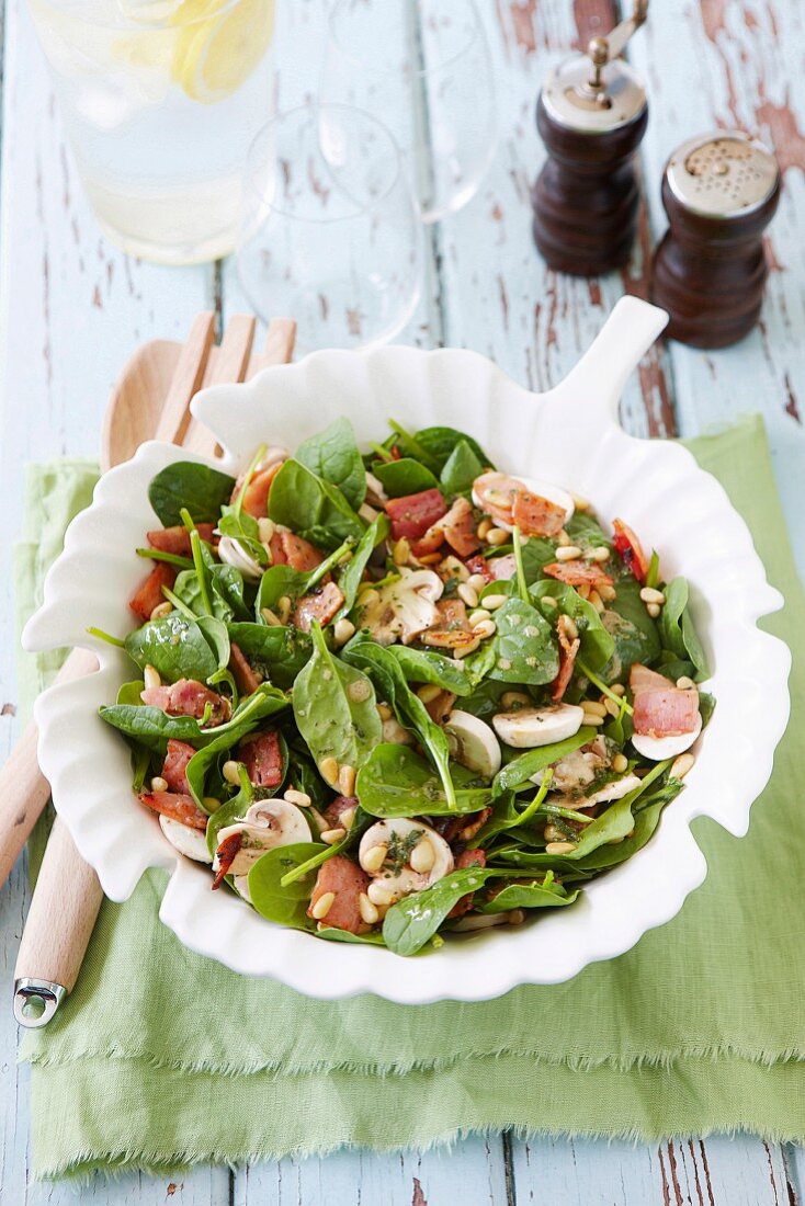 Spinach salad with mushrooms, bacon and pine nuts