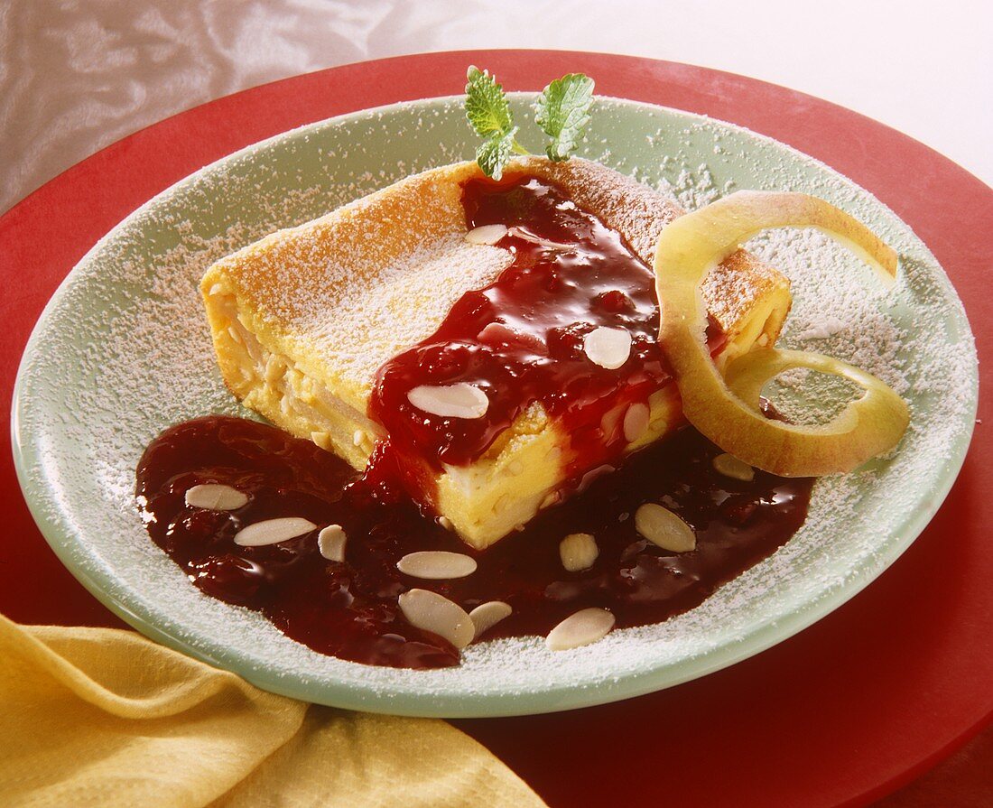 A piece of lemon cake with plum sauce & powdered sugar