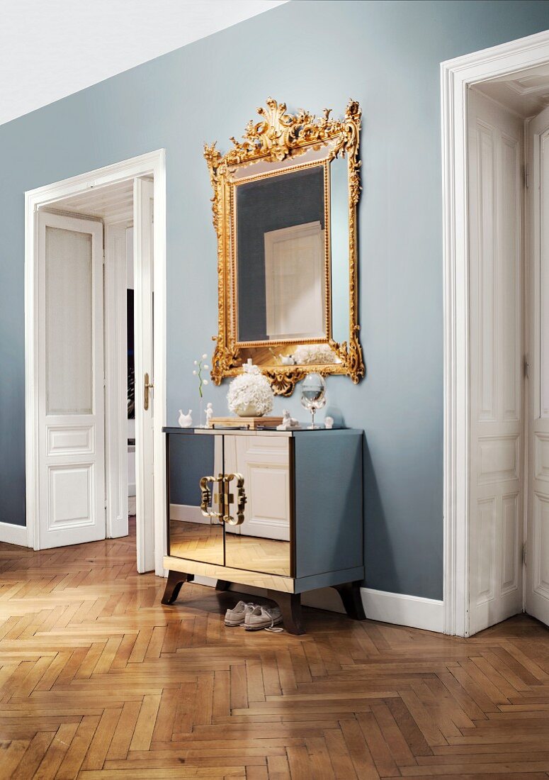 Opulenter Barock-Spiegel kombiniert mit verspiegelter Art-Deco Kommode in stilvollem Wiener Altbauflur
