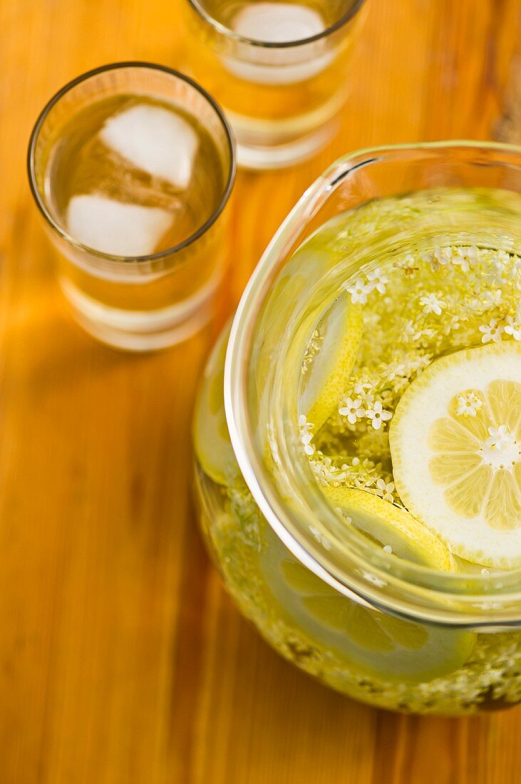 Elderflower juice with lemon in a glass jug and in glasses