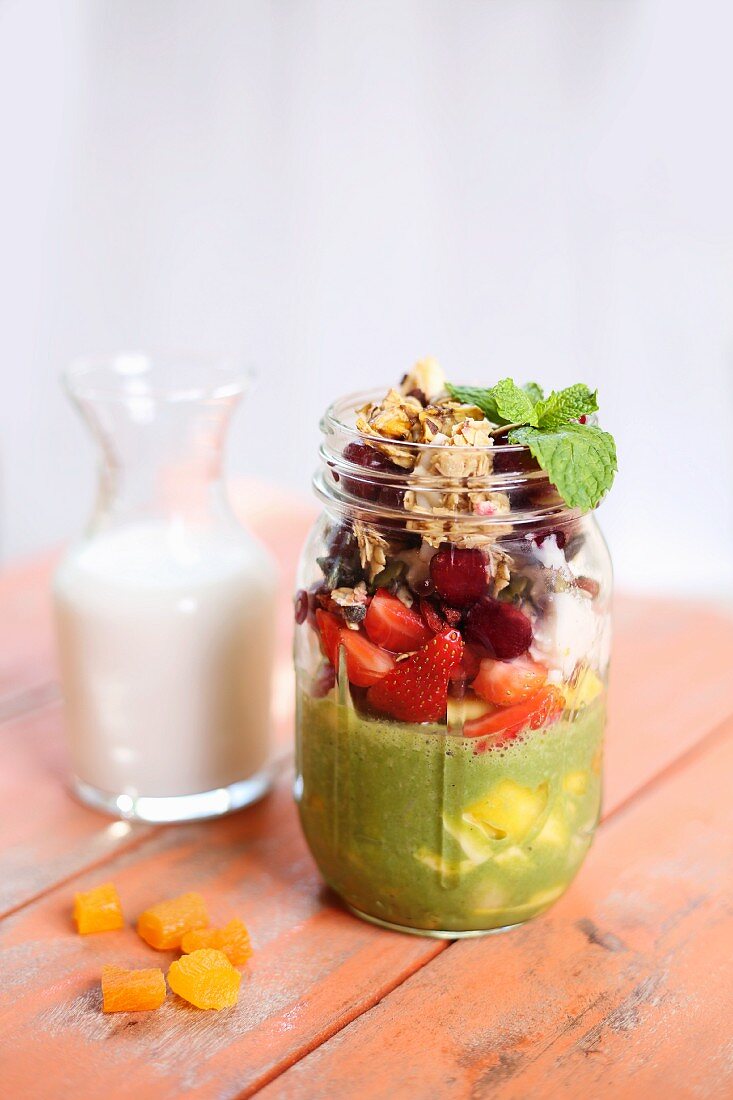 Breakfast parfait with pumpkin seed milk, berries and dried apricots