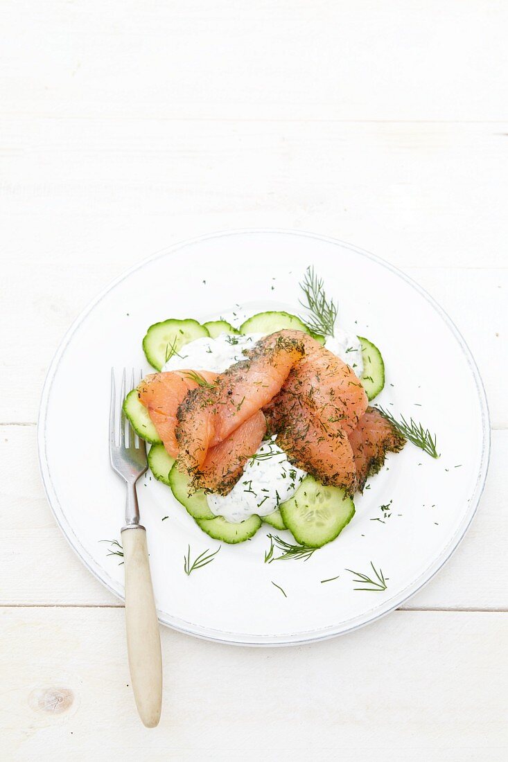 Smoked salmon on a bed of cucumber slices with sour cream and dill