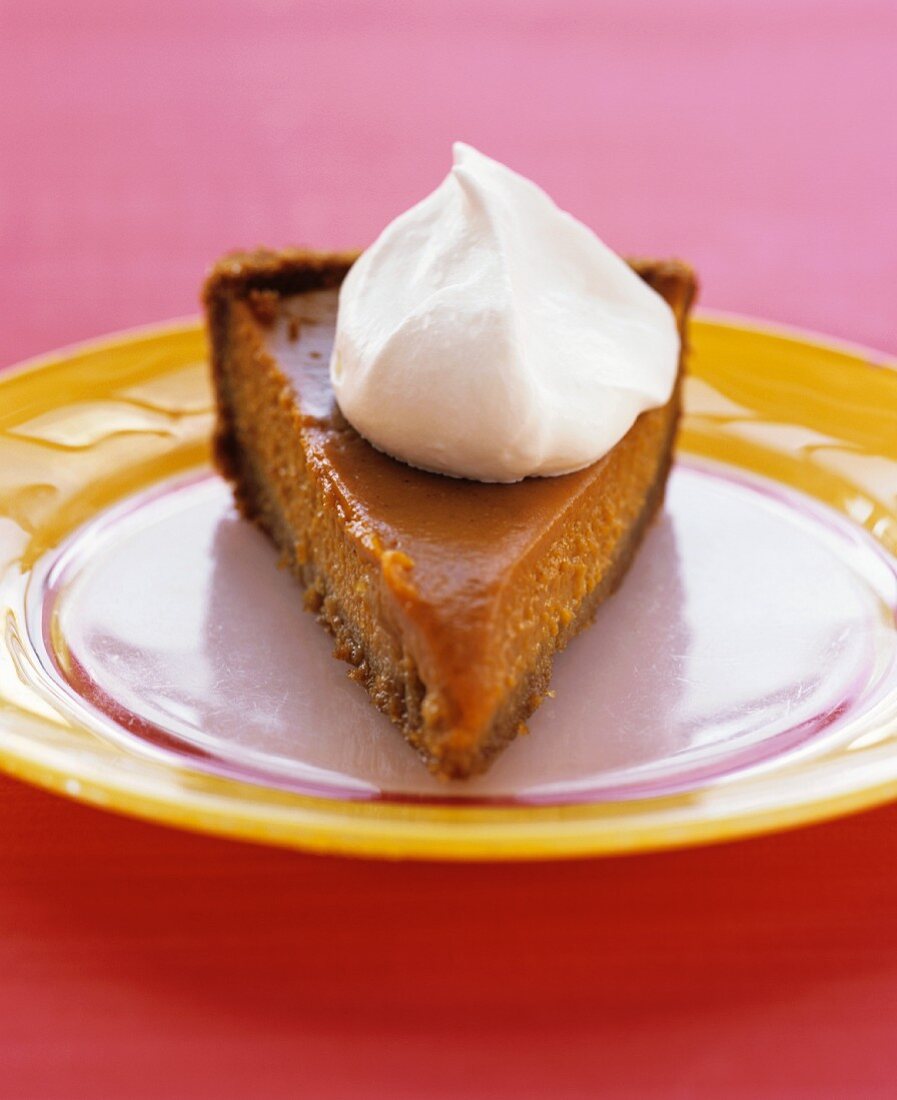 A slice of sweet potato pie with a dollop of cream