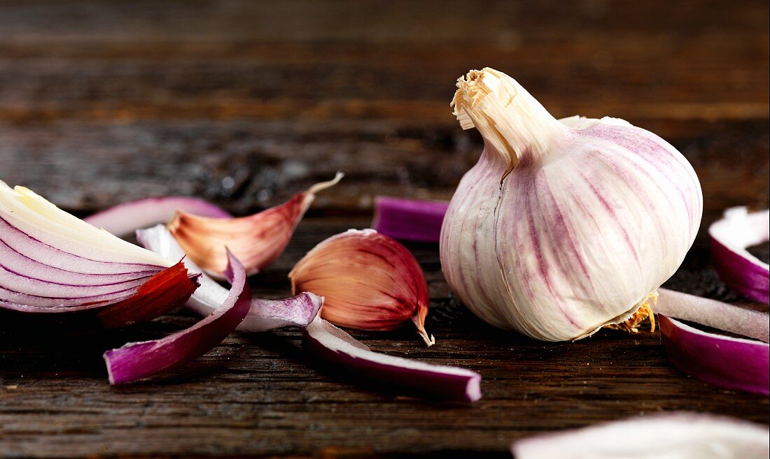 A red onion and garlic on a wooden surface