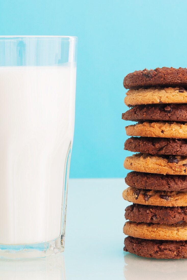 Ein Glas Milch neben einem Stapel Cookies