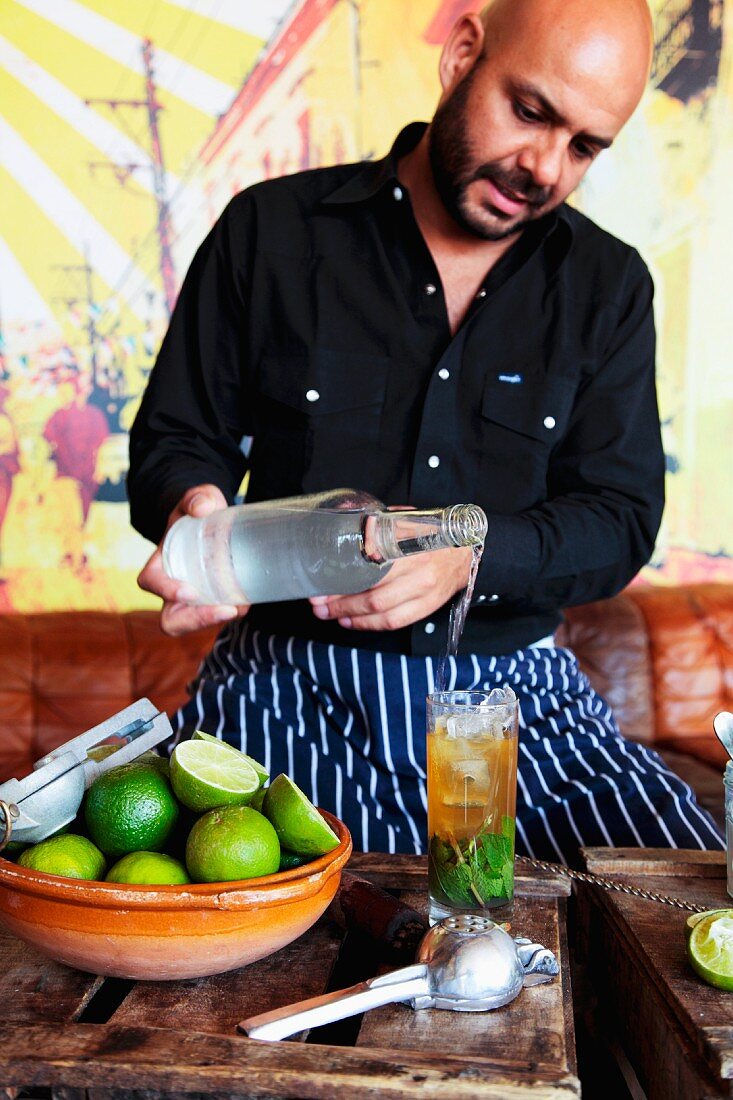 A mojito being made (white rum being added)