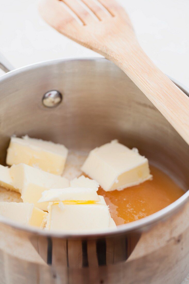 Butter, sugar and honey in a pan with a wooden spatula
