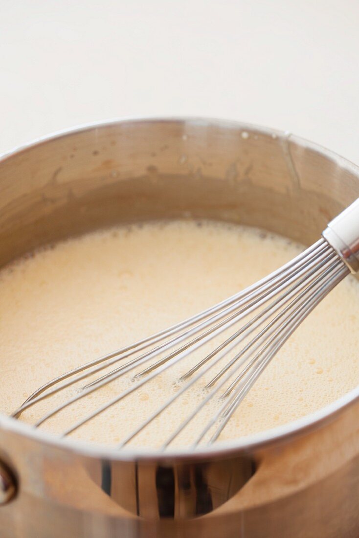 Melted butter with sugar and eggs in a pan with a whisk