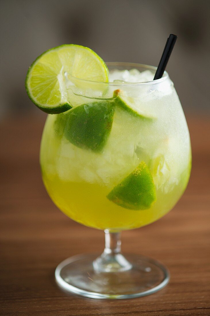A cocktail with limes and ice cubes