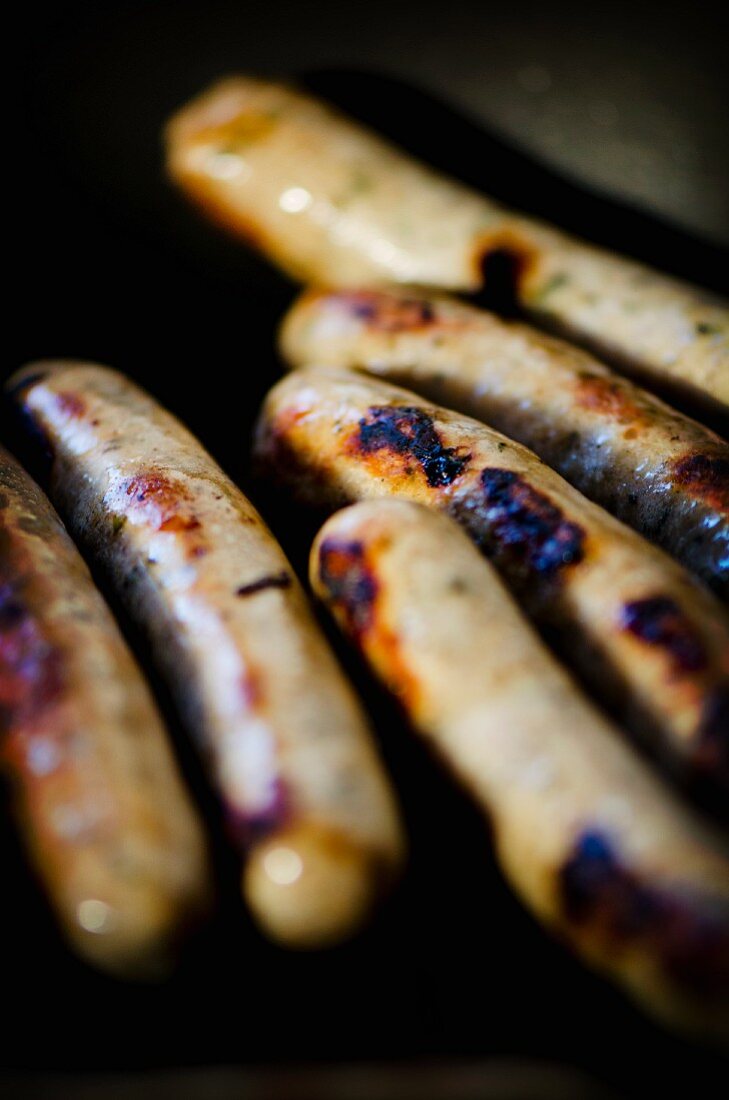 Charred Nuremberg sausages in a pan (close-up)