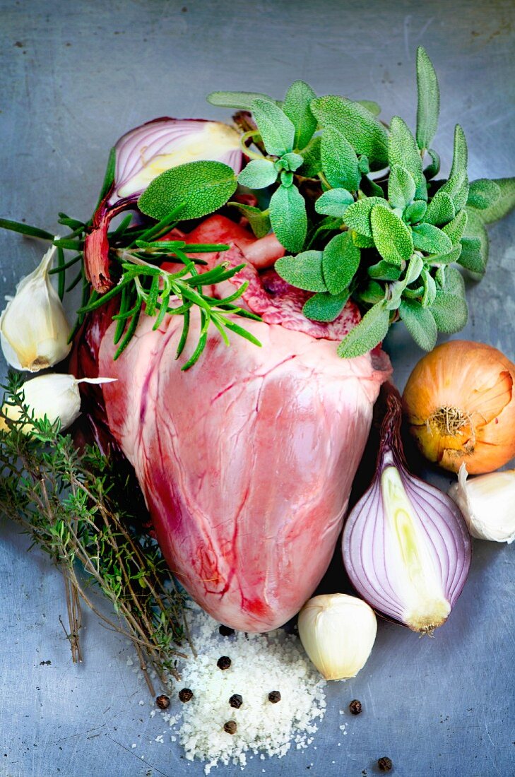 A whole pig's heart surrounded by sage, rosemary, thyme, onions, garlic, salt and pepper