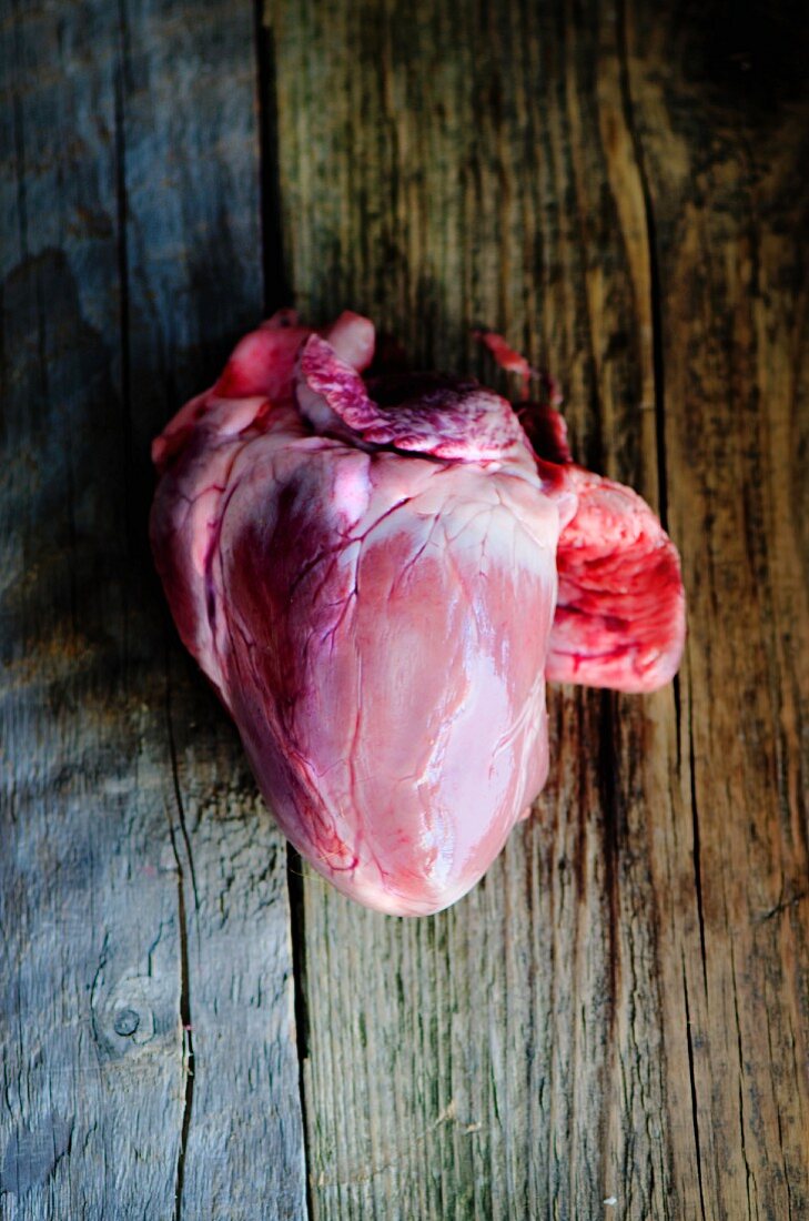 A fresh pig's heart on a wooden board