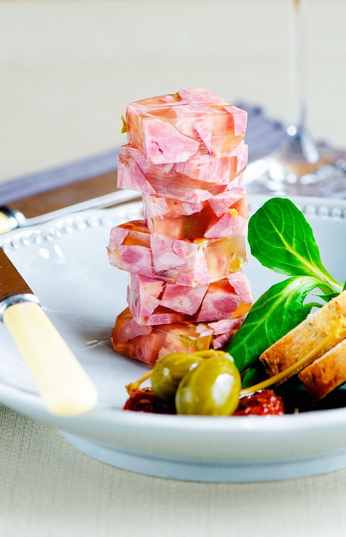 Brawn with giant capers, slices of bread and lambs lettuce