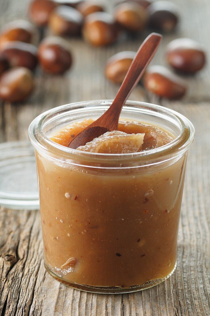 A jar of chestnut cream with a wooden spoon