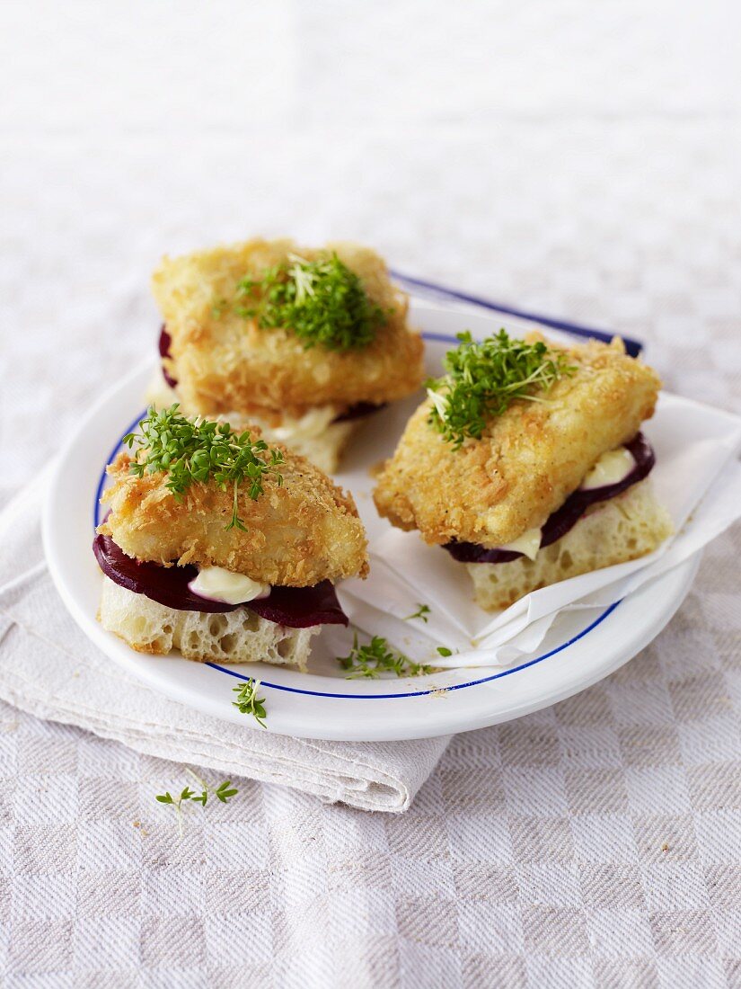 Slices of bread topped with battered fish and cress