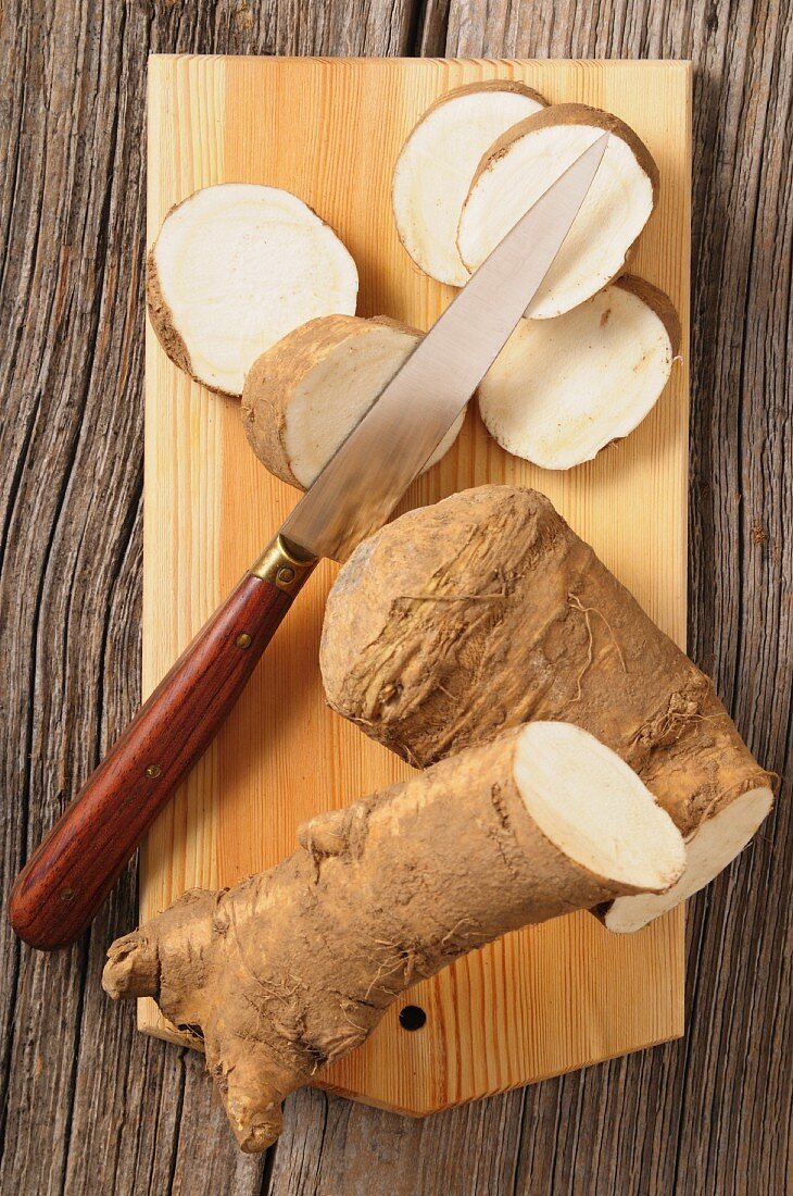 Fresh horseradish on a chopping board with a knife