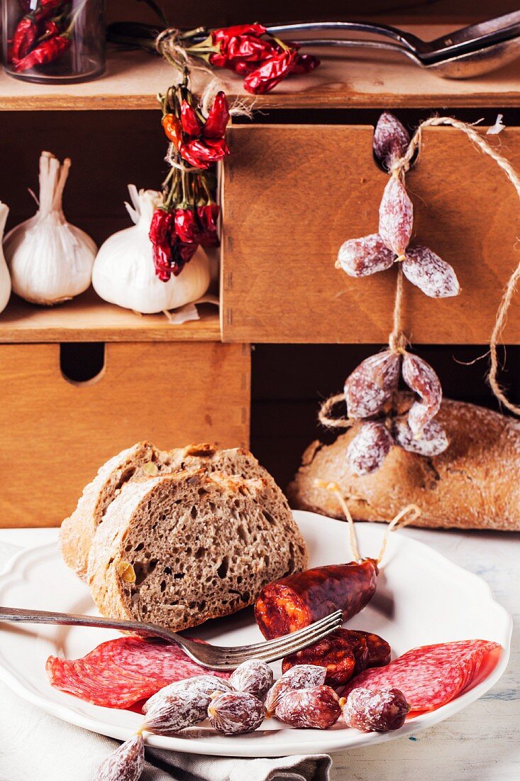 Verschiedene Salami- & Wurstsorten mit Brot auf Teller